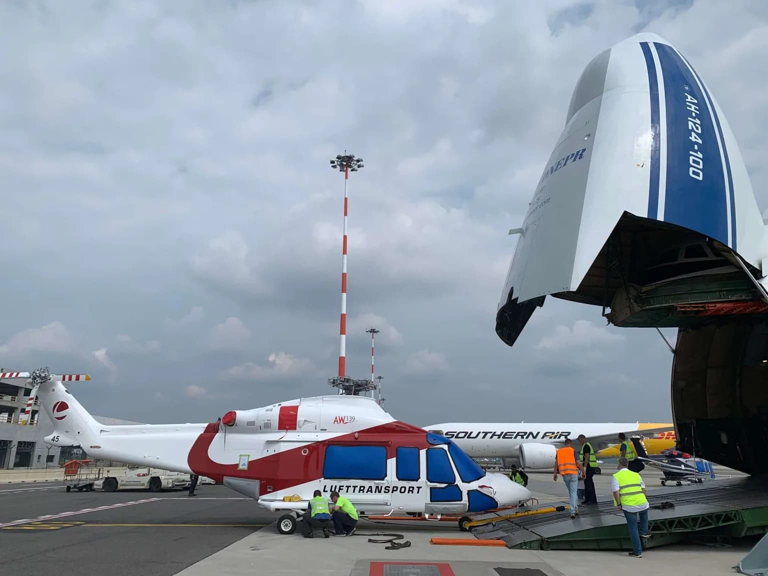 Antonov 124 freighter loading helicopter cargo at sunset